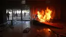 Demonstran mengamuk membakar gedung Kementerian Pertanian dalam unjuk rasa anti-pemerintah di Brasilia, Brasil, Rabu (24/5). Ribuan demonstran bergerak ke ibu kota menuntut pengunduran diri Presiden Michel Temer. (AP Photo/Eraldo Peres)