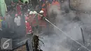 Petugas menyemprotkan air ke puing-puing yang terbakar untuk memastikan api benar-benar padam, Palmerah, Jakarta, Kamis (4/8). Api yang diduga berasal dari arus pendek itu membakar 8 rumah. (Liputan6.com/Immanuel Antonius)