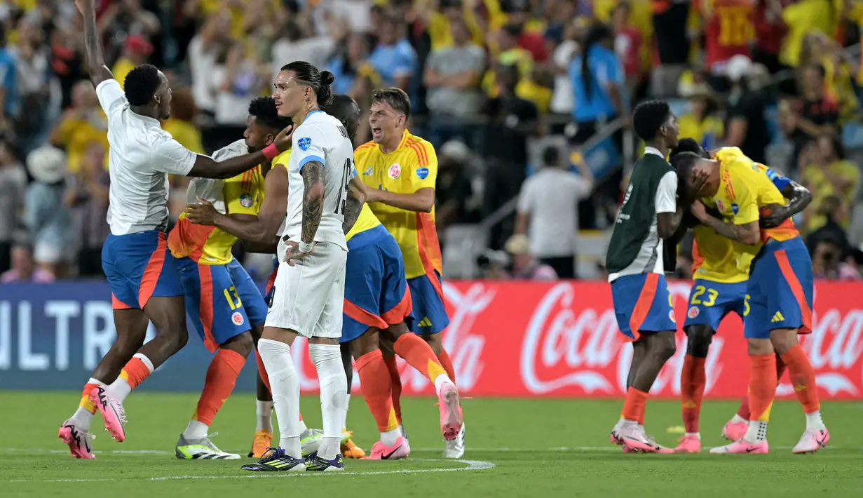 Reaksi kecewa striker Timnas Uruguay, Darwin Nunez di antara para pemain Timnas Kolombia yang merayakan kemenangan 1-0 usai berakhirnya laga semifinal Copa America 2024 di Bank of America Stadium, Charlotte, Amerika Serikat, Kamis (11/7/2024) pagi WIB. (AFP/Juan Mabromata)