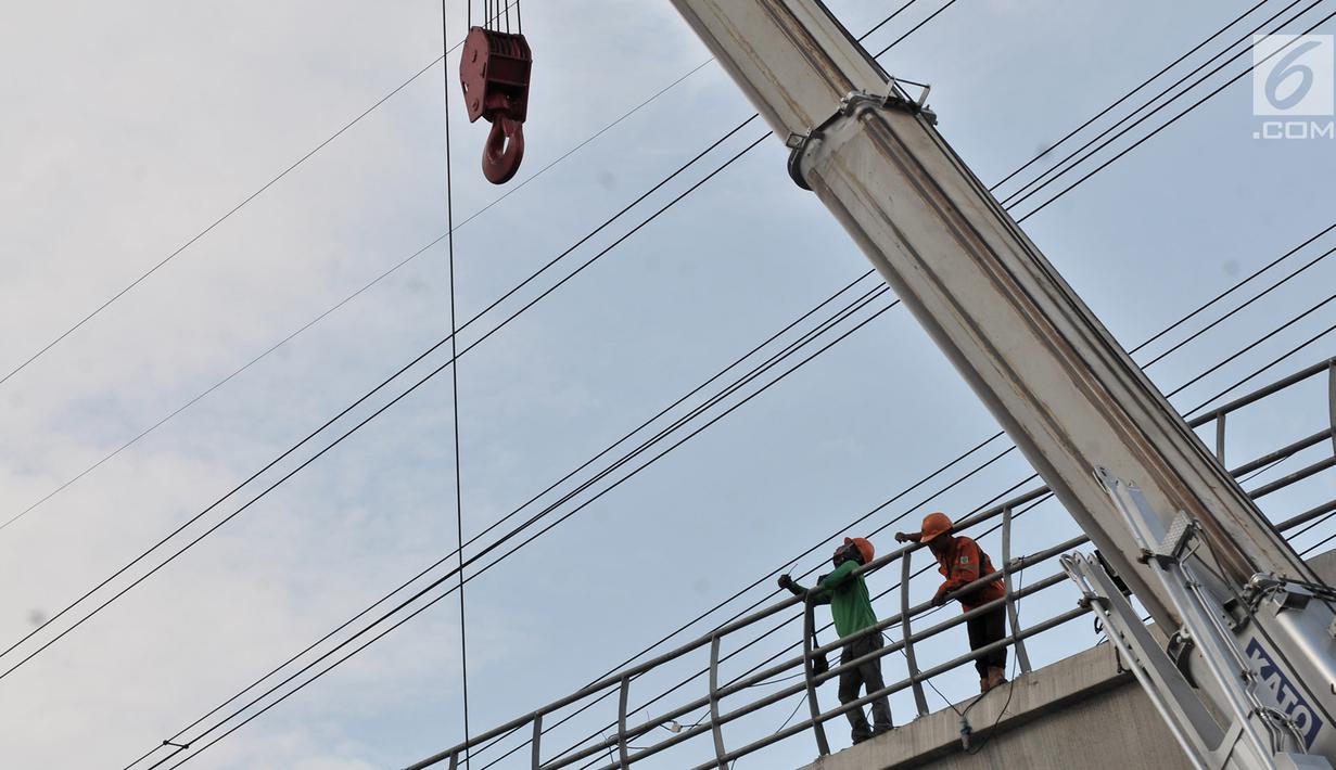 Aktivitas pekerja menyelesaikan proyek LRT Jabodebek di kawasan Cibubur, Jakarta, Senin (18/2). Tarif flat untuk moda transportasi massal ini ditetapkan setelah mendapat kepastian subsidi dari pemerintah. (Merdeka.com/Iqbal S. Nugroho)