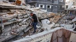 Para pria melihat reruntuhan rumah yang hancur akibat serangan Israel di Khan Younis, Jalur Gaza selatan, pada Rabu 29 Oktober 2025. Diketahui pula, Israel menggempur Khan Younis, Gaza Tengah, dan bahkan di perkemahan pengungsi Bureij. (BASHAR TALEB/AFP)