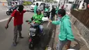 Ojek online (ojol) menerima bantuan berupa bingkisan makan siang dan hand sanitizer di kawasan Jalan Raden Saleh, Jakarta, Selasa (7/3/2020). Bantuan dari DPP PKB guna meringankan beban ojol yang sepi orderan akibat lesunya perekonomian selama pandemi corona Covid-19. (Liputan6.com/Fery Pradolo)