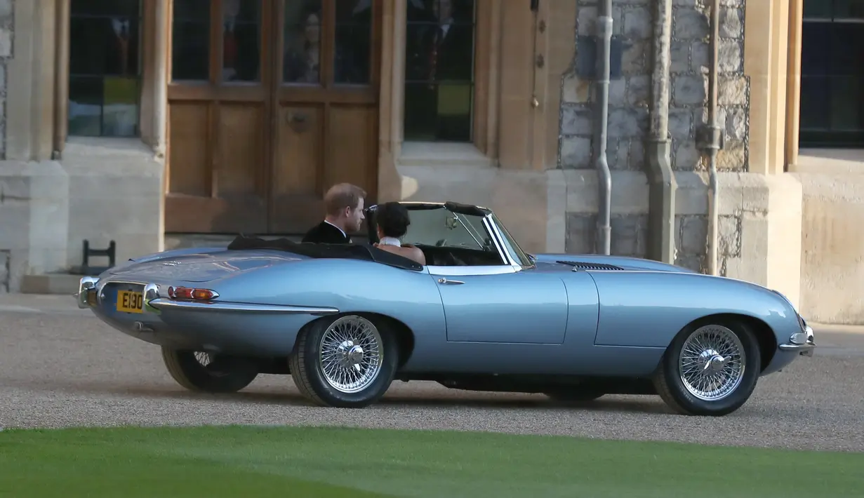 Pangeran Harry dan istrinya Meghan Markle meninggalkan Kastil Windsor (19/5). Jaguar Classic E-Type Concept Zero tahun 1968 ini telah direstorasi dan tak lagi menggunakan mesin konvensional tapi motor listrik. (AFP Photo/Pool/Steve Parsons)