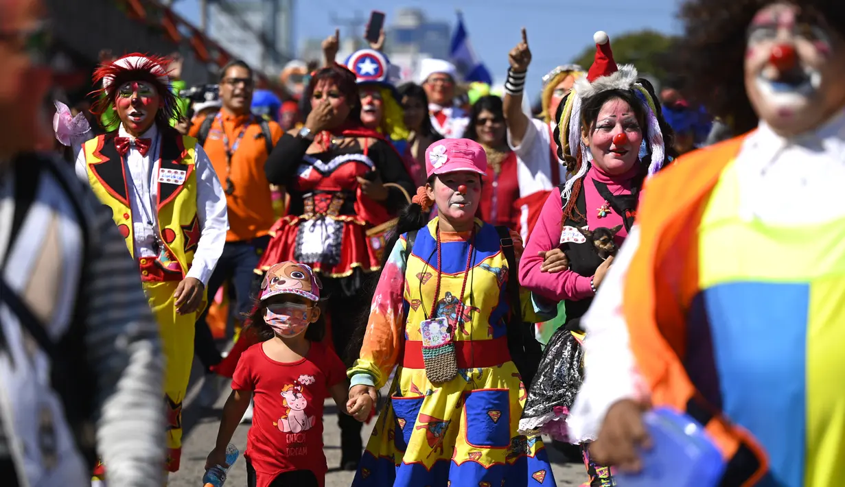 Badut berpartisipasi dalam parade untuk merayakan Hari Badut Nasional Salvador di San Salvador pada 7 Desember 2022. El Salvador telah menetapkan Rabu pertama di bulan Desember sebagai Hari Badut Nasional. (Photo by Marvin RECINOS / AFP)