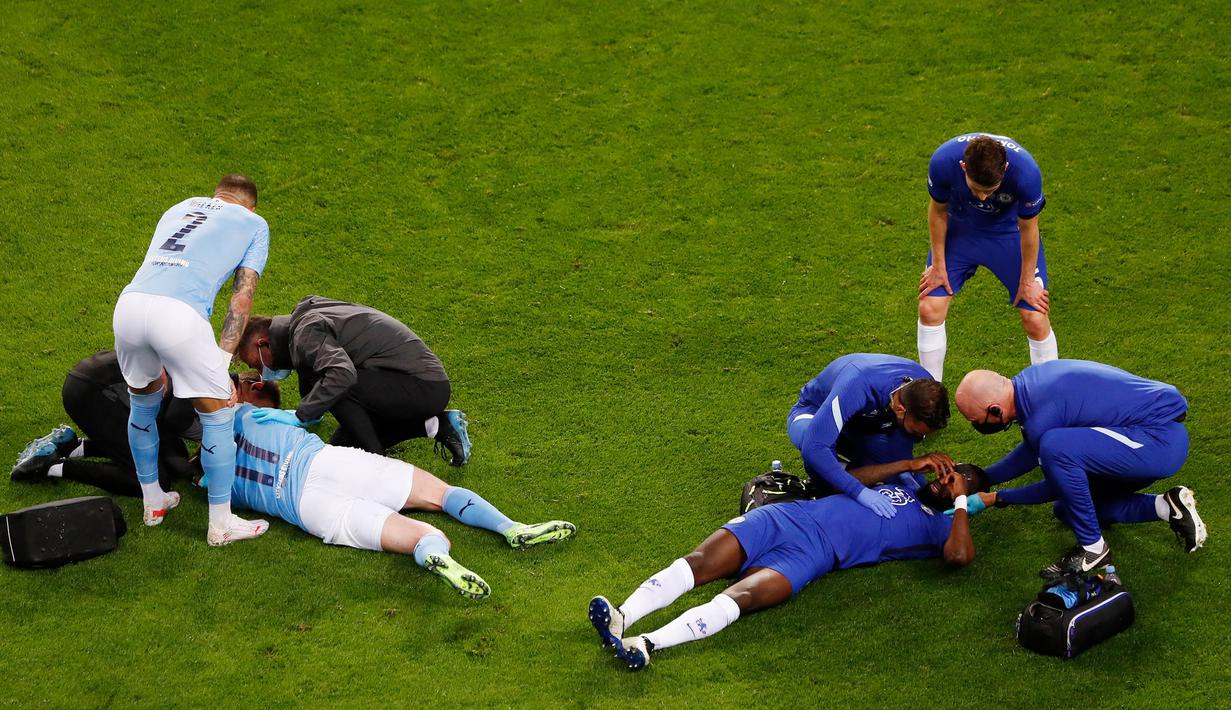 Antonio Rudiger (kanan) dan Kevin De Bruyne (kiri) menerima perawatan setelah bertabrakan selama pertandingan final Liga Champions antara Manchester City dan Chelsea di Stadion Dragao di Porto, Portugal, Sabtu (29/05/2021) atau Minggu dini hari WIB. (Foto: AFP/Pool/Susana Vera)