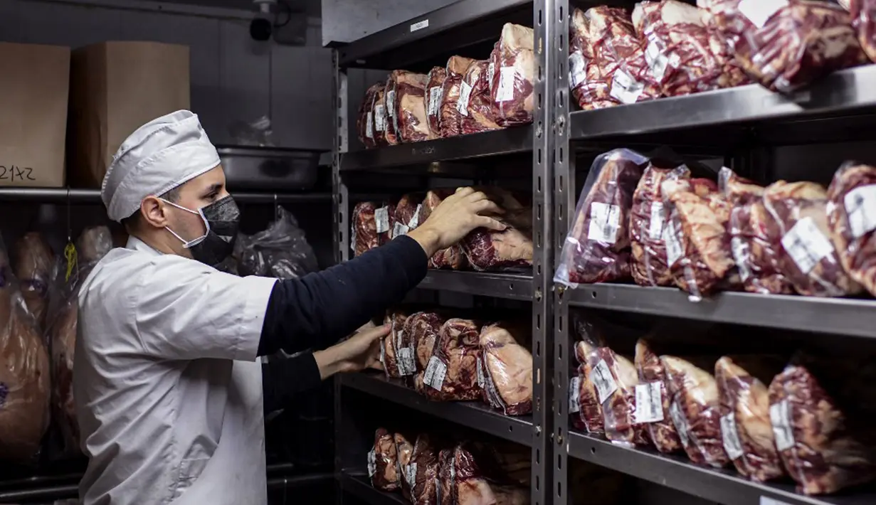 Seorang tukang daging bekerja di toko daging di restoran Don Julio di lingkungan Palermo, Buenos Aires, Argentina, Kamis (20/5/2021). Penghentian ekspor daging sapi mendapat penolakan dari asosiasi bisnis Argentina. (RONALDO SCHEMIDT/AFP)
