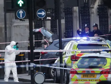 Petugas forensik meneliti lokasi serangan teror Inggris di dekat gedung parlemen di London, Rabu (22/3). Sedikitnya lima orang tewas dalam serangan teror di Jembatan Westminster dan di dekat Gedung Parlemen itu. (Yui Mok/PA via AP)