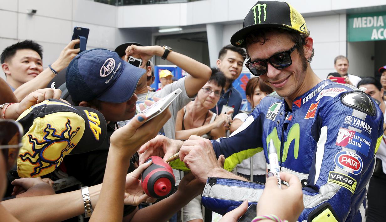 Valentino Rossi melayani tanda tangan penggemarnya setelah latihan bebas GP Malaysia di Sirkuit Sepang, Malaysia, (23/10/2015). (Reuters/Olivia Harris)