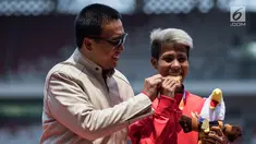 Atlet lompat jauh Indonesia, Rica Oktavia (kanan) foto bersama Menpora Imam Nahrawi usai meraih medali emas Asian Para Games 2018 di SUGBK, Jakarta, Senin (8/10). Rica menorehkan lompatan mencapai 5,25 meter. (Bola.com/Vitalis Yogi Trisna)