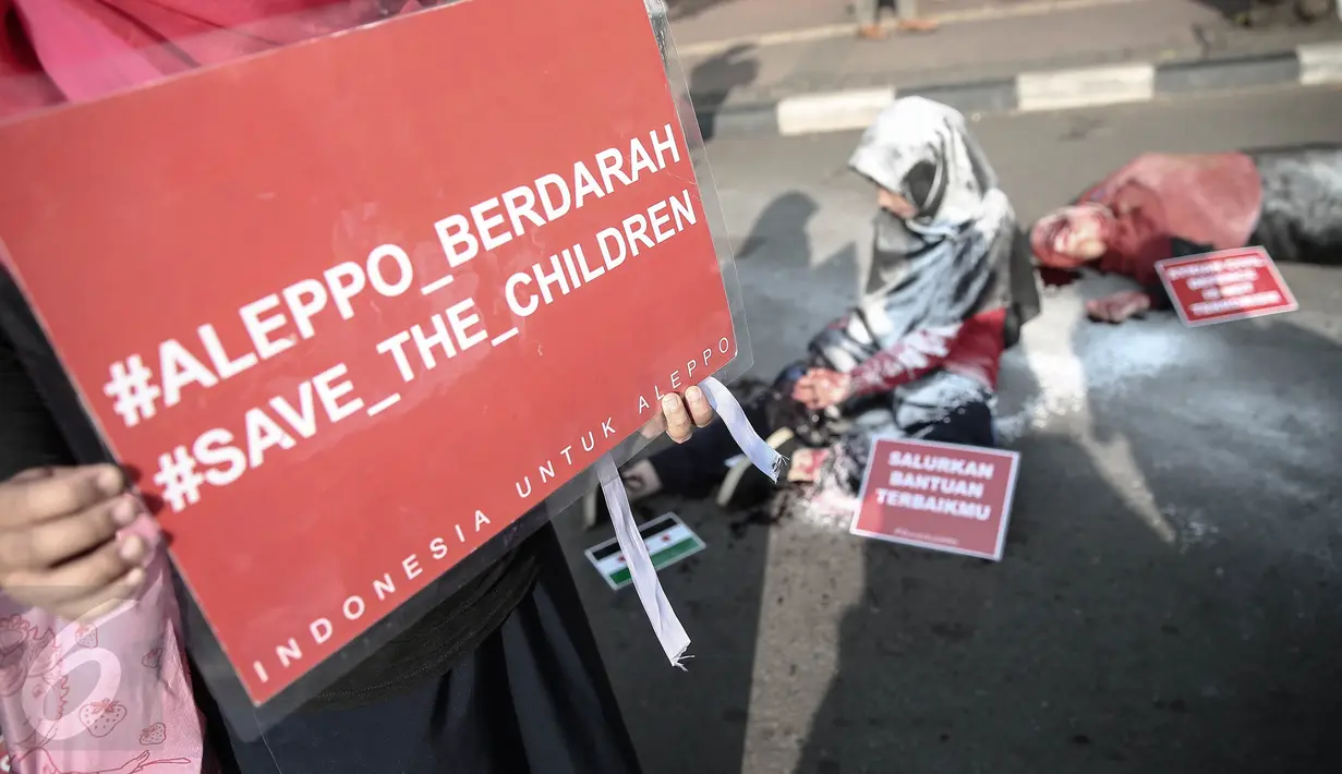 Peserta melakukan teatrikal saat aksi solidaritas peduli Suriah bertema 'Stop Suriah Memerah Darah' di car free day Bundaran HI, Jakarta, Minggu (8/5). Selain di Jakarta, aksi ini dilakukan pula di sejumlah kota besar lain. (Liputan6.com/Faizal Fanani)