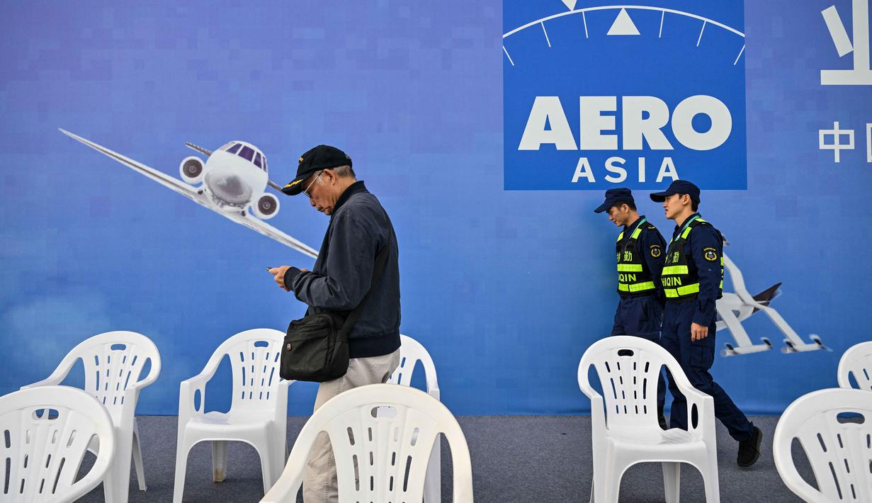 AERO Asia 2025 juga menghadirkan 70 acara pendukung yang membahas keberlanjutan dan inovasi, dengan target kunjungan mencapai 60.000 orang. Tampak dalam foto, seorang pengunjung dan penjaga terlihat selama Aero Asia 2025 di Zhuhai, Provinsi Guangdong, Tiongkok selatan, pada Kamis 27 November 2025. (Hector RETAMAL/AFP)