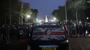 Taksi yang menampilkan foto sang Ratu berjalan di antara kerumunan di The Mall saat orang-orang berkumpul di luar Istana Buckingham, setelah pengumuman kematian Ratu Elizabeth II, di pusat kota London pada 8 September 2022. Ratu Elizabeth II menjadi salah satu wanita paling terkenal yang pernah hidup. Putranya, Charles, segera menjadi raja setelah kematiannya. (ISABEL INFANTES / AFP)