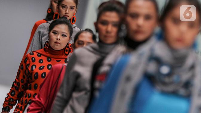 Model disabilitas memperagakan busana rancangan kolaborasi Cotton Ink x Intoart yang digawangi British Council pada Jakarta Fashion Week 2020 di Senayan, Kamis (24/10/2019). Kolaborasi ini menampilkan model disabilitas yang terdiri dari down syndrome, tuna daksa dan tuli. (Liputan.com/Johan Tallo)
