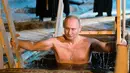 Presiden Rusia Vladimir Putin berendam di air dingin di Danau Seliger di desa Svetlitsa, Rusia (19/1). Ribuan pengikut Gereja Ortodoks Rusia akan berendam ke sungai dan kolam es merayakan Epiphany. (Alexei Druzhinin, Sputnik, Kremlin Pool Photo via AP)