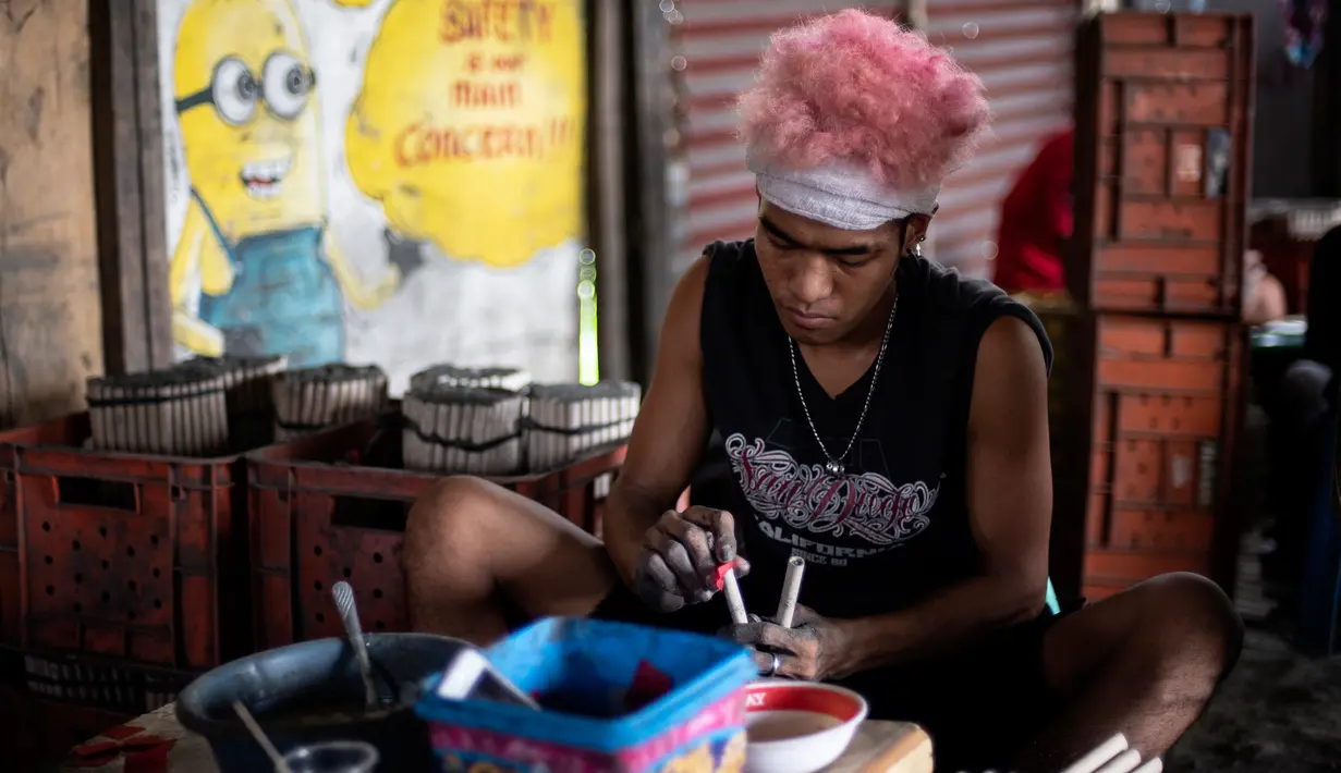 Pekerja menyelesaikan pembuatan kembang api untuk perayaan Tahun Baru 2019 di Bocaue, Bulacan, Manila Utara (26/12). (AFP Photo/Noel Celis)