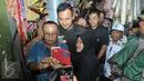 Sejumlah warga berebut untuk berfoto bareng dengan Cagub DKI Jakarta Agus Harimurti Yudhoyono di Pasar Senen, Jakarta, Selasa (8/11). Selain meminta doa dan dukungan, Agus juga mendengarkan keluhan para pedagang Pasar Senen. (Liputan6.com/Yoppy Renato)
