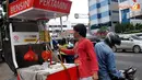 Dari tabung itu bensin kemudian dialirkan melalui selang untuk diisikan pada pembeli (Liputan6.com/Johan Tallo)