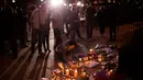 Seorang wanita menyalakan lilin sehari setelah serangan bunuh diri di sebuah konser Ariana Grande di Albert Square, Manchester, Inggris, (23/5). (AP Photo/Emilio Morenatti)