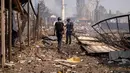 Petugas kepolisian memeriksa lokasi setelah serangan Rusia menghantam sebuah gudang di desa Myla, wilayah Kyiv, Ukraina, pada hari Sabtu, 29 Agustus 2026. (Foto AP/Dan Bashakov)