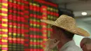 Seorang investor mengamati papan indeks bursa saham di Haikou, provinsi Hainan, China, 11 Agustus 2015. Langkah Bank Sentral China menurunkan nilai tukar yuan terhadap dolar AS langsung membuat pelaku pasar ketakutan. (REUTERS/Stringer CHINA OUT)