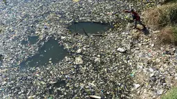 Warga mencari sampah plastik untuk didaur ulang di aliran Sungai Citarum, Bandung, Jawa Barat, Rabu (26/6/2019). Berbagai upaya dilakukan pemerintah untuk membersihkan sungai yang menyandang predikat salah satu tempat paling tercemar di dunia ini. (Timur Matahari/AFP)