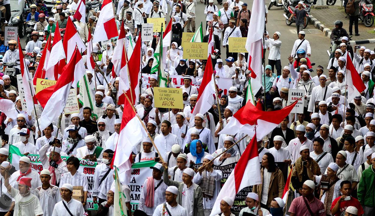 Massa aksi damai 4 November mulai bergerak menuju Masjid Istiqlal, Jakarta Pusat, yang dijadikan titik kumpul, Jumat (4/11). Mayoritas demonstran tampak menggunakan pakaian berwarna putih dan membawa berbagai bendera. (Liputan6.com/Faizal Fanani)