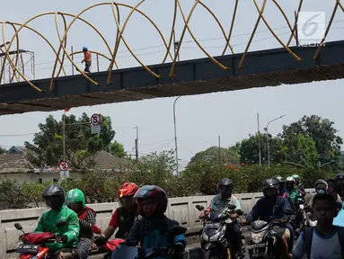 Kendaraan melintas di bawah proyek pembangunan Jembatan Penyebaran Orang (JPO) Pasar Minggu di Jakarta Selatan, Kamis (26/9/2019). JPO berdesain artistik senilai Rp 7 miliar tersebut ditargetkan rampung pengerjaannya pada Desember 2019 mendatang. (Liputan6.com/Immanuel Antonius)