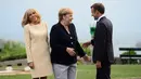 Presiden Prancis Emmanuel Macron (kanan) dan istrinya Brigitte Macron (kiri) menyambut Kanselir Jerman Angela Merkel (tengah) yang tiba di KTT G7, Biarritz, Prancis, Sabtu (24/8/2019). KTT G7 ini berlangsung selama tiga hari di resor tepi laut Atlantis. (Sean Kilpatrick/The Canadian Press via AP)