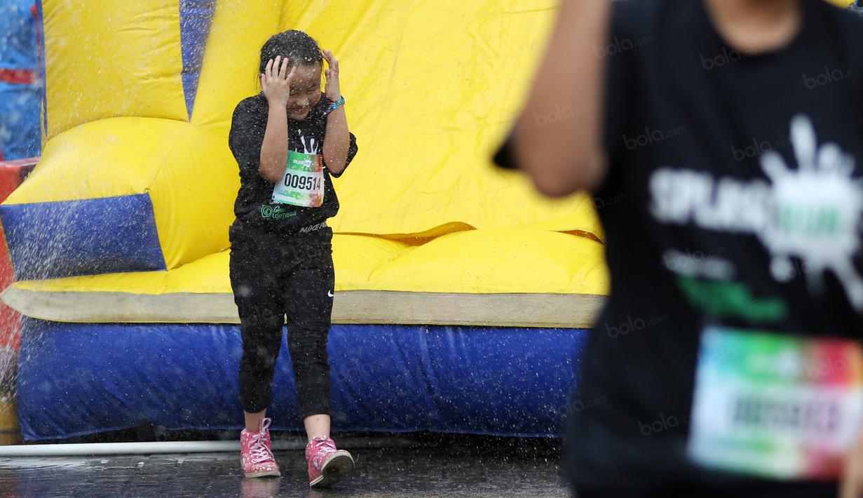 Ekspresi pelari cilik saat melewati rintangan semprotan air pada ajang Splash Run di Pantai Carnaval Ancol, Sabtu (30/7/2016). (Bola.com/Nicklas Hanoatubun)