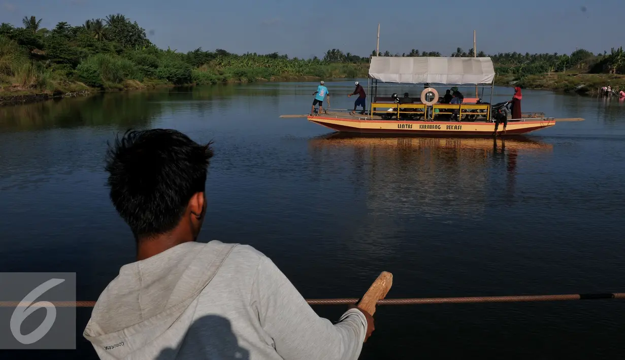 Pekerja menarik perahu eretan berisi kendaraan menyebrangi Sungai Citarum di Muara Gembong, Bekasi, Rabu, (29/7/2015). Kendaraan yang menyebrang menggunakan perahu eretan dikenakan biaya Rp.20.000 bagi mobil dan Rp 2.000 motor. (Liputan6.com/Johan Tallo)