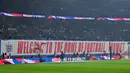 Pendukung Timnas Inggris membentangkan banner untuk menyambut debut Thomas Tuchel sebagai pelatih saat laga Kualifikasi Piala Dunia 2026 melawan Albania di Wembley Stadium, London, Jumat (21/03/2025) waktu setempat. (AFP/Glyn Kirk)