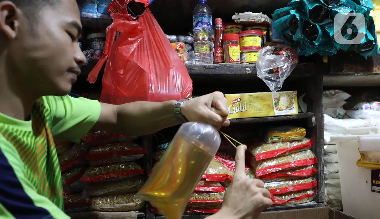 Pedagang tengah mengemas minyak curah di Pasar Kebayoran Lama, Jakarta, Jumat (15/7/2022). Berdasarkan Sistem Pemantauan Pasar Kebutuhan Pokok (SP2KP) Kementerian Perdagangan, harga minyak goreng curah hari ini, Jumat (15/7/2022) berada di level Rp15.200 per liter secara nasional. Harga ini tercatat turun yakni Rp15.236 pada Kamis (14/7/2022). (Liputab6.com/Angga Yuniar)