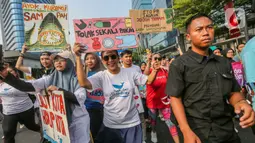 Di lokasi, Susi Pudjiastuti yang memakai kaus berwarna putih itu mengajak masyarakat memerangi pemakaian plastik sekali pakai. (Liputan6.com/Faizal Fanani)