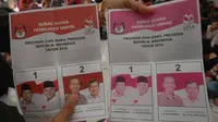 Petugas Komisi Pemilihan Umum (KPU) memperlihatkan lembaran surat suara Pemilihan Presiden 2014 yang rusak. (ANTARA FOTO/Adeng Bustomi)