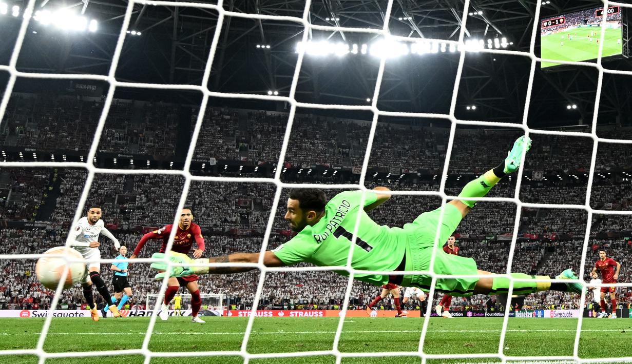 Penjaga gawang AS Roma, Rui Patricio, berhasil menggagalkan tendangan dari pemain Sevilla pada laga final Liga Europa 2022/2023 yang berlangsung di Puskas Arena, Budapest, Kamis (1/6/2023) dini hari WIB. (AFP/Odd Andersen)