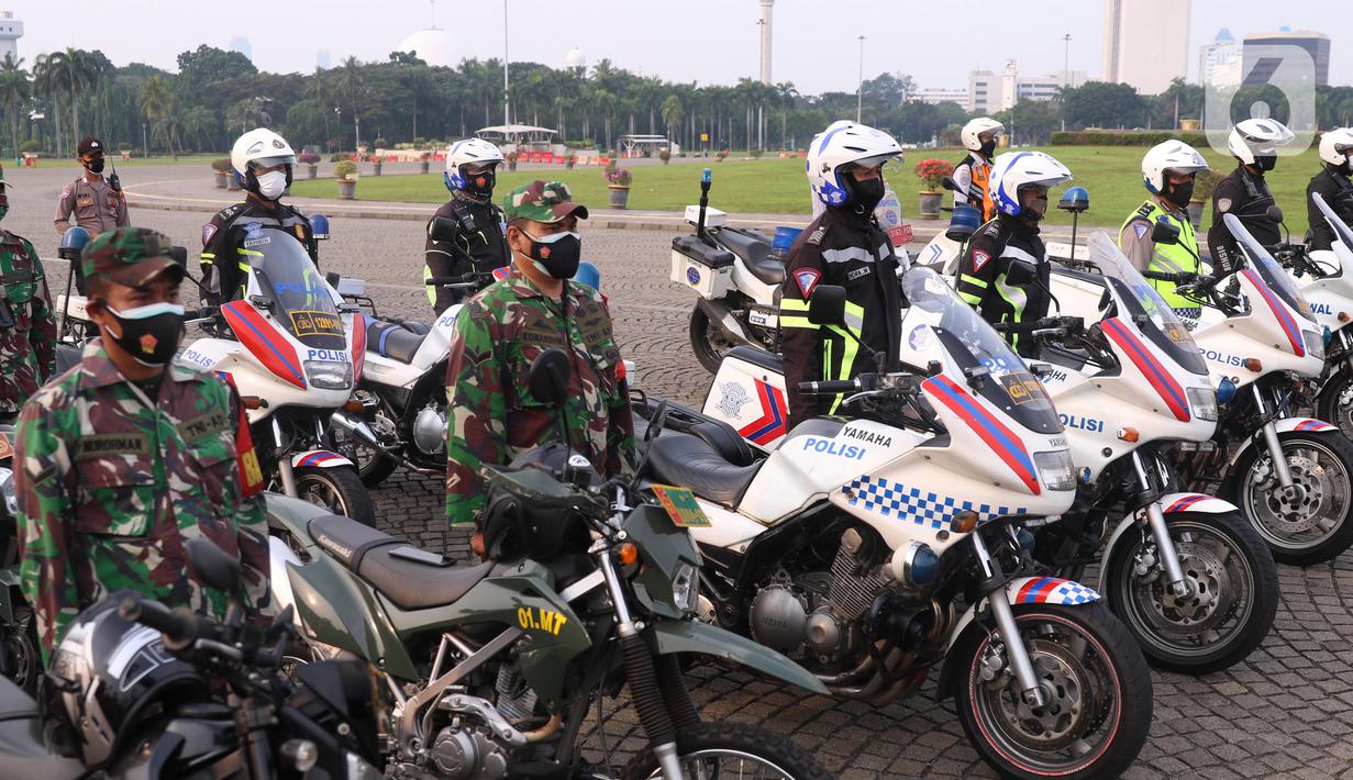 Personil gabungan melakukan apel pasukan pengamanan di Monas, Jakarta, Senin (19/7/2021). Pengamanan tersebut dilakukan untuk menjaga Hari Raya Idul Adha 1442 Hijriah dimasa pandemi Covid-19 saat PPKM Darurat. (Liputan6.com/Angga Yuniar)
