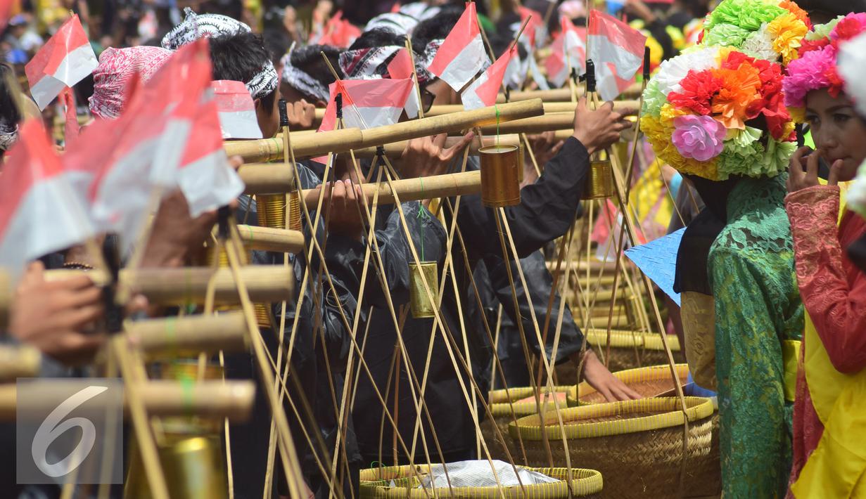 Peserta pria memikul bakul saat pawai Tradisi Ngarot di Indramayu, Minggu, (9/10). Ngarot merupakan upacara adat menyongsong datangnya musim hujan, yaitu tibanya musim tanam padi. (Liputan6.com/Gholib)