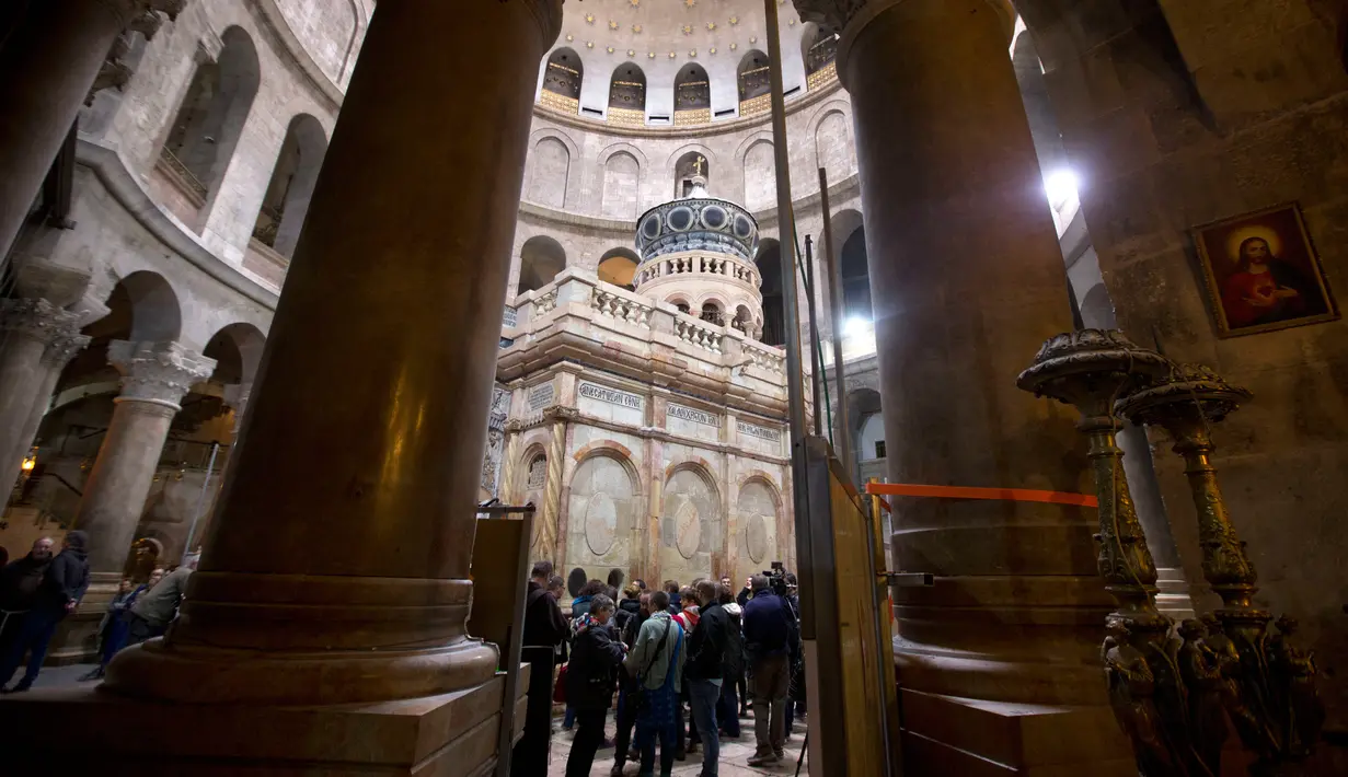 Sejumlah pengunjung sedang melihat Edicule yang terletak didalam Gereja Makam Kudus di Yerusalem (20/3). Gereja tersebut merupakan salah satu yang tertua, dibangun pada 325 M oleh Kaisar Konstantin dari Romawi. (AP Photo/Sebastian Scheiner)
