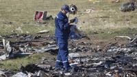 Seorang petugas melakukan penyelidikan di lokasi jatuhnya pesawat Malaysia Airlines MH17 di Desa Hrabove, daerah Donetsk, Ukraina timur. (VOA Indonesia)