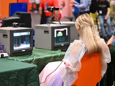 Seorang pengunjung memainkan permainan retro di pameran video game Gamescom di Cologne, Jerman bagian barat pada 23 Agustus 2023. (AFP/Ina Fassbeder)