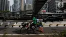 Seorang pedagang melintas di jalur sepeda permanen di jalan Sudirman, Jakarta, Rabu (24/2/2021). Pemprov DKI Jakarta mulai mempermanenkan jalur sepeda di Jalan Sudirman - Thamrin, Jakarta Pusat. (Liputan6.com/Johan Tallo)