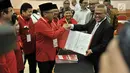 Sekjen PDIP Hasto Kristiyanto (kiri) menyerahkan daftar bakal caleg ke Ketua KPU Arif Budiman (kanan) di Gedung KPU, Jakarta, Selasa (17/7). (Merdeka.com/Iqbal Nugroho)