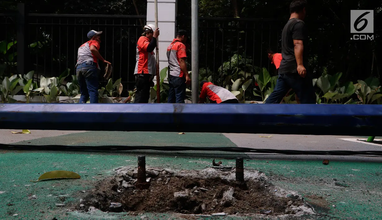 Petugas mencabut tiang listrik di trotoar Jalan Asia Afrika dan Jalan Gelora, Jakarta, Rabu (1/8). Pembuatan jalur sepeda ini sempat menuai protes akibat tiang listrik dan lampu jalan menghalangi, sehingga menyulitkan pesepeda. (Liputan6.com/Johan Tallo)