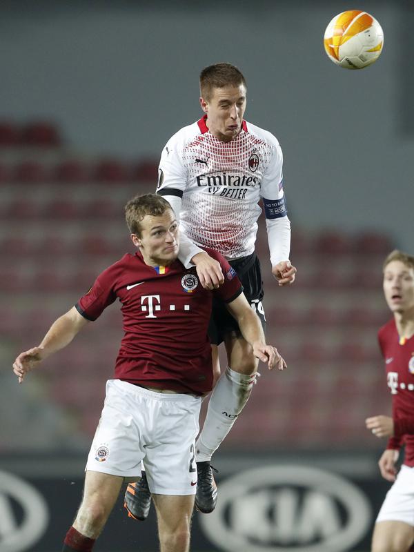 Gelandang Sparta Praha, Matej Polidar menantang bek AC Milan, Andrea Conti pada pertandingan grup H Liga Eropa UEFA di Stadion Generali Arena, Jumat (11/12/2020) dinihari WIB. AC Milan menutup fase grup Liga Europa dengan kemenangan tipis 1-0 atas tuan rumah Sparta Praha. (AP Photo/Petr David Josek