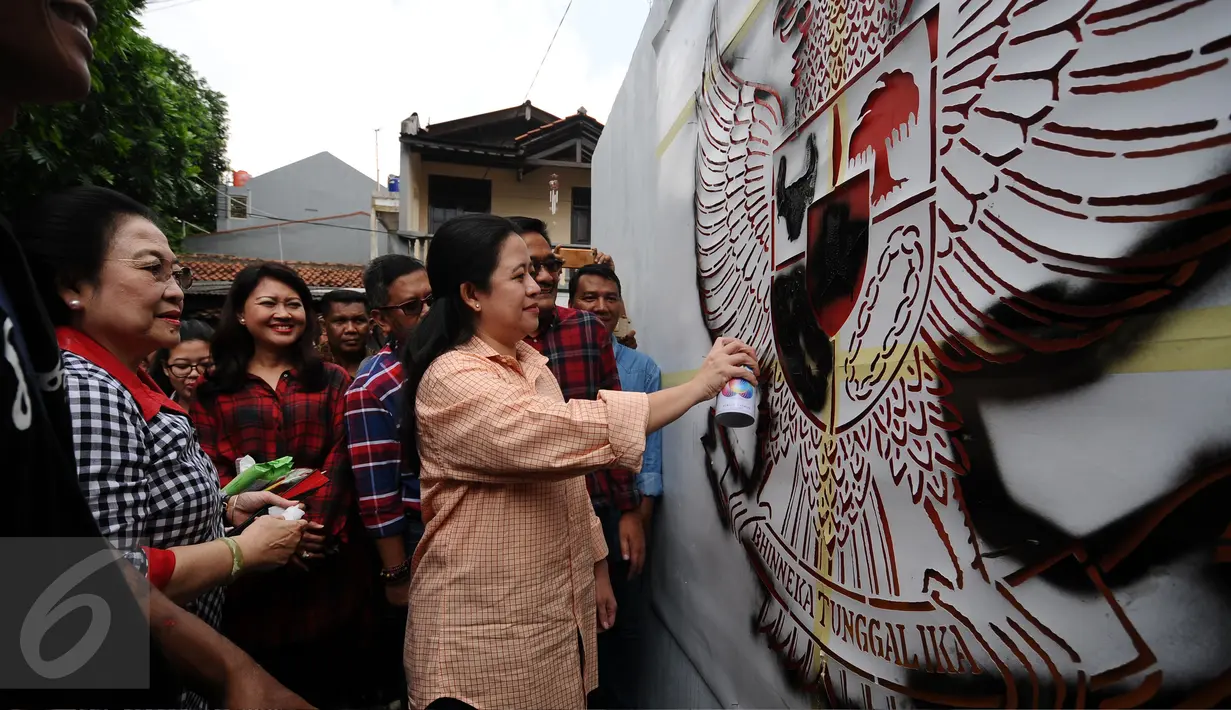 Presiden ke-5 RI Megawati Soekarnoputri menyaksikan Menko PMK, Puan Maharani mewarnai mural Garuda Pancasila di dinding TPS sebelum mengikuti pencoblosan Pilkada DKI 2017, di TPS 027 Kebagusan, Jakarta, Rabu (15/2). (Liputan6.com/Helmi Fithriansyah)