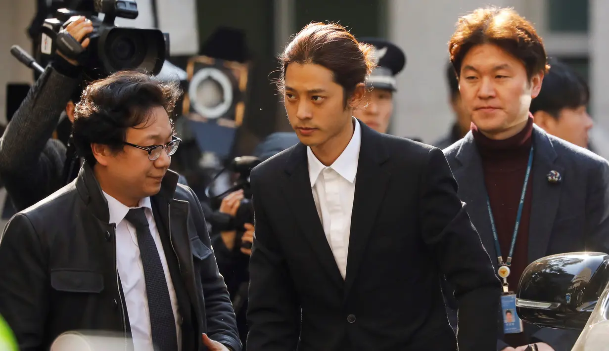 Penyanyi Korea Selatan, Jung Joon Young tiba untuk menjalani pemeriksaan di Kantor Polisi Metro Seoul, Kamis (14/3). Jung Joon Young dituduh melakukan rekaman  secara ilegal dan membagikannya di media sosial. (REUTERS/Kim Hong-Ji)