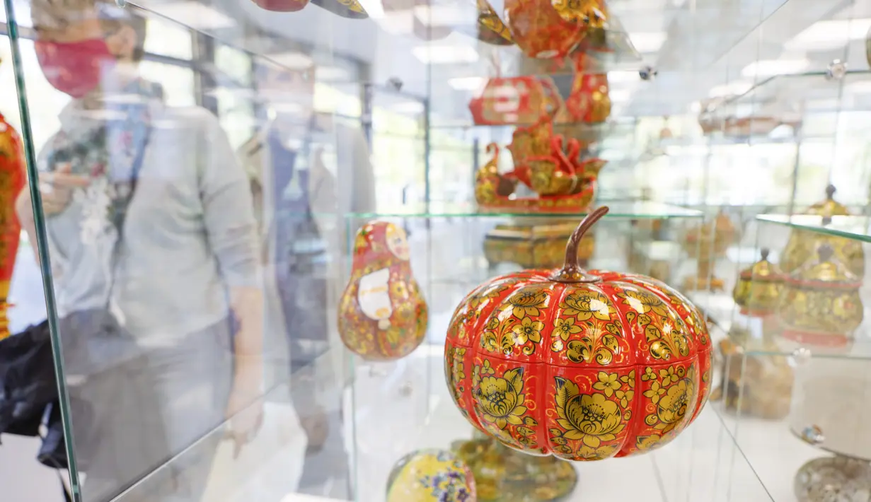 Orang-orang yang memakai masker mengunjungi pameran kesenian rakyat tradisional Rusia di Moskow, Rusia, 4 Oktober 2020. Lebih dari 1.000 karya seni tradisional Rusia buatan produsen kerajinan terkemuka dipamerkan di acara tersebut. (Xinhua/Alexander Zemlianichenko Jr)
