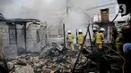 Petugas pemadam kebakaran menyemprotkan air untuk memadamkan api saat terjadi kebakaran di Jalan Kampung Muka, Pademangan, Jakarta, Selasa (25/4/2023). (Liputan6.com/Faizal Fanani)