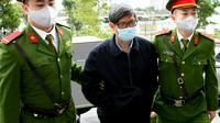 Mantan menteri kesehatan Vietnam Nguyen Thanh Long (tengah) divonis penjara karena korupsi atas suap produksi alat tes COVID-19 di Hanoi. Daam foto saat sidang pada 3 Januari 2024. (AFP)