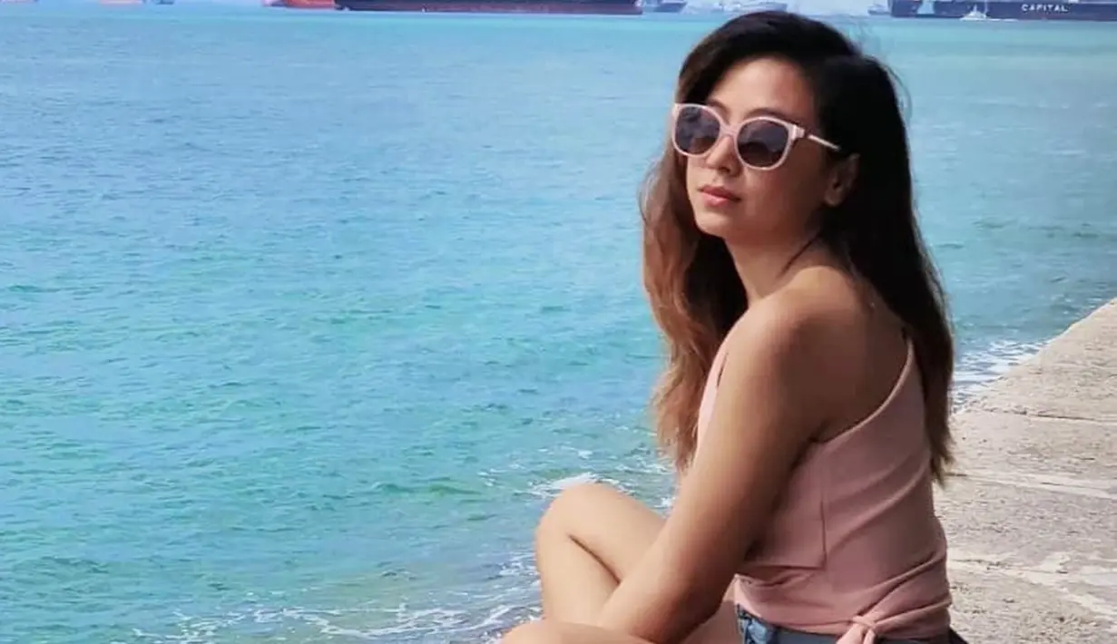 Ini dia penampilan Nadia Vega saat tengah bersantai di pantai. Ia terlihat menggunakan pakaian berwarna peach dan mengkombinasikan dengan kacamata hitam yang memiliki frame senada dengan busananya. (Liputan6.com/IG/@thenadiavega)